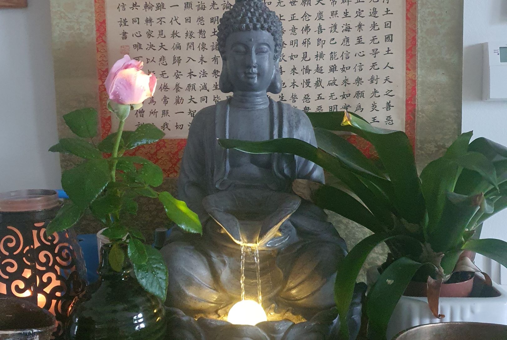 Buddha Statue mit Lotusblüte vor Kalligraphie